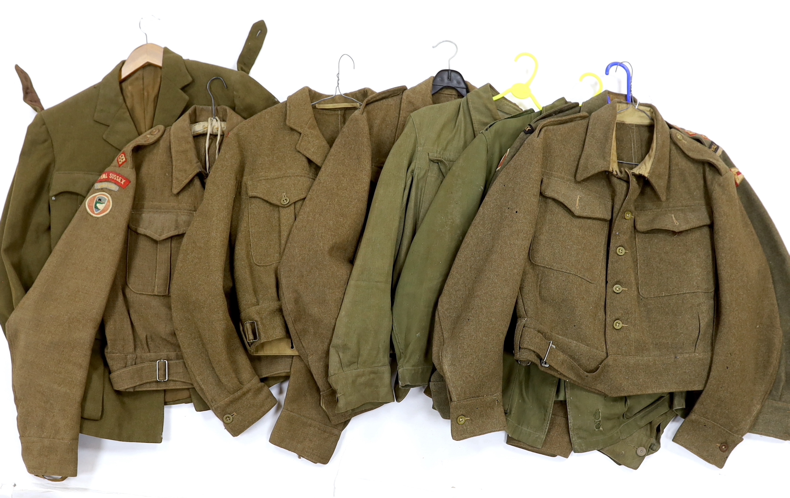 Eight British military uniform blouses/jackets, including two with Royal Sussex Regiment Cinque Ports shoulder insignia, a Queen’s A.C.F. example, etc.